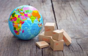 Miniature globe and boxes on wooden background